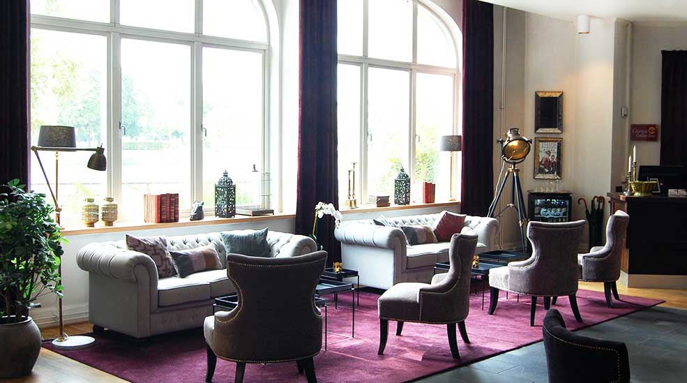 Lobby översikt med fåtöljer och soffor mot fönster på Clarion Collection Hotel Bolinder Munktell Eskilstuna 