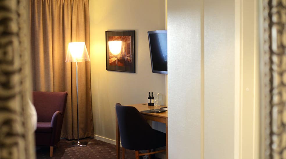 Skrivbord med sitthörna och tv i superoirrum på Clarion Collection Hotel Kompaniet Nyköping