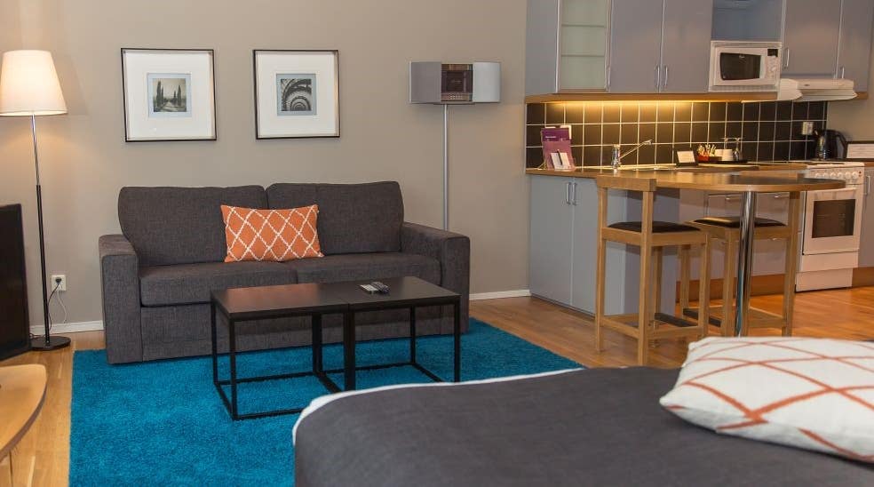Vardagsrum med soffa och kök i superior dubbelrum på Clarion Collection Hotel Odin Göteborg 