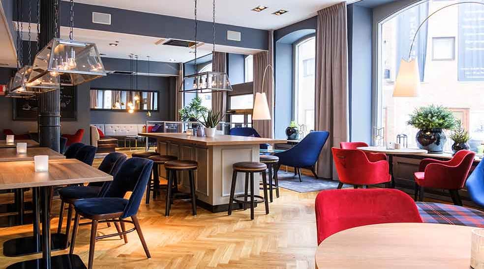 Sittplatser i restaurangen med fåtöljer och serveringsbord på Clarion Collection Hotel Temperance i Malmo