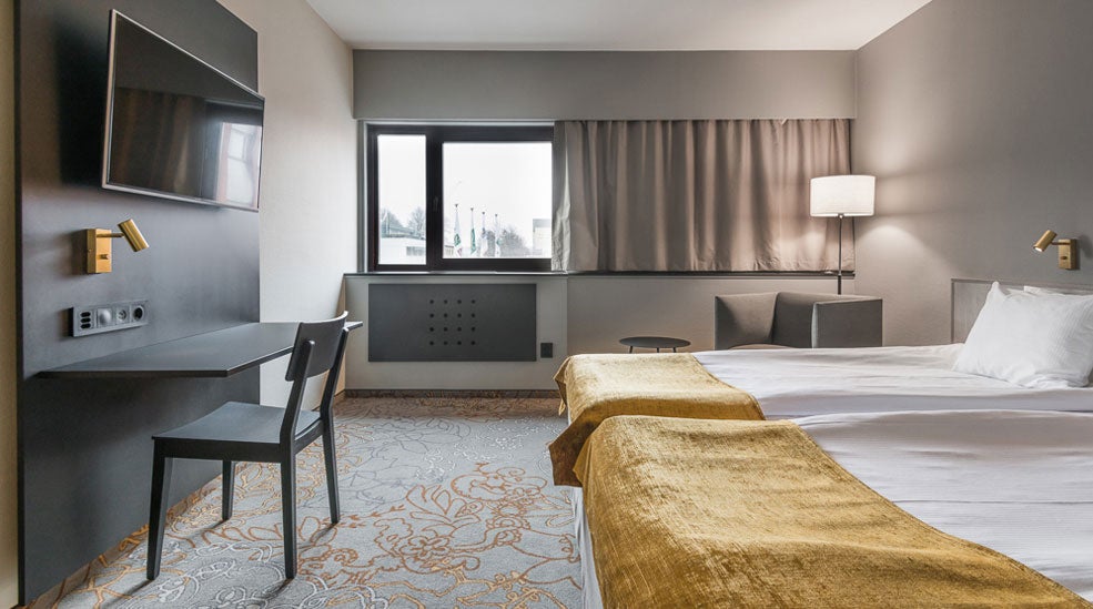 Tv, skrivbord och stol, fönster och säng i Superior dubbelrum på Quality Hotel Royal Corner
