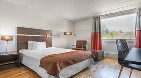 Dubbelsäng, arbetsyta, fönster och fåtölj i Moderate dubbelrumm på Quality Hotel Winn, Göteborg
